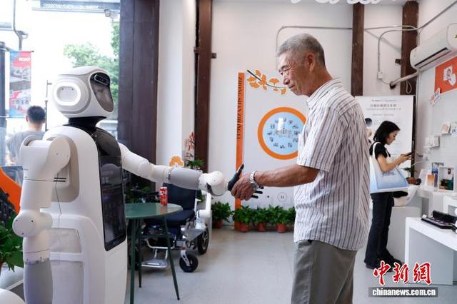 老人与智能康养机器人握手互动。肖健 摄